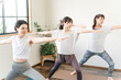 © buritora - Women learning yoga and Pilates in a yoga class (Warrior Pose)