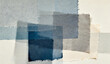 © yanli - Abstract composition of layered blue and gray fabric swatches with frayed edges on a neutral background