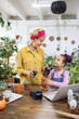© sofiko14 - A woman and a young girl are potting plants, creating a heartwarming scene of family and gardening