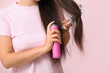 © Pixel-Shot - Beautiful young woman with hair spray on pink background, closeup