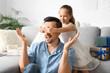 © Pixel-Shot - Little daughter making her father surprise in living room. Father's Day celebration