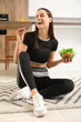 © Pixel-Shot - Beautiful young happy woman with bowl of fresh salad sitting in kitchen at home. Weight loss concept