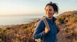 © JONATHAN - Smiling woman hiker wearing a backpack and blue fleece, enjoying a beautiful scenic coastal view from a mountain trail during golden hour.