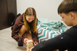 © dizfoto1973 - Teenagers Playing Wooden Block Stacking Game Indoors - Happy Friends Having Fun and Concentrating Together