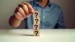 © Md Fazly Rabby - Hand hold Wooden cube block in question mark mean what on cement table background, column of wooden blocks with question sign mark. copy space,FAQ frequently asked questions, Answer, Information