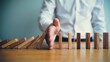 © MD Imran - Strategic hand intervention halts domino chain reaction, symbolizing effective risk management, crisis prevention, and business control to avert negative consequences