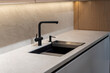© Sergey - Matte black kitchen sink and faucet on gray stone countertop