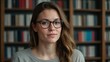 © Leandson - Young female student wearing glasses in a library environment
