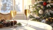 © Haya - Two champagne flutes stand on a table decorated for the holidays with a snowy tree and window backdrop