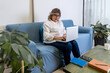© FABIAN PONCE GARCIA - Confident mature woman working remotely on laptop at home