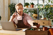 © Bliss - Handsome florist skillfully manages business while engaging with customers in vibrant studio