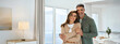 © insta_photos - Smiling affectionate loving middle aged couple, happy romantic mature older Latin man and woman in their 50s hugging looking at camera standing together in modern kitchen at home. Portrait.