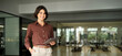 © insta_photos - Portrait of young Hispanic professional business woman standing in office. Happy female company executive, smiling businesswoman entrepreneur corporate leader manager looking at camera using tablet.