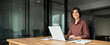 © insta_photos - Portrait of confident businesswoman leader in her 30s at work desk. Smiling Hispanic young woman entrepreneur, happy female executive manager looking at camera sitting at work with laptop.