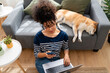 © mahalo studio/Stocksy - Woman working from home with sleeping dog