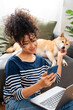 © mahalo studio/Stocksy - woman working remotely with dog companion