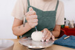 © Tania Cervian/Stocksy - Crop artisan using tool on clay