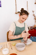 © Tania Cervian/Stocksy - Young woman mixing clay with hands
