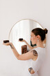 © Tania Cervian/Stocksy - Woman near mirror carrying ceramic bowl