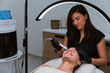 © Manu Padilla/Stocksy - Beautician performing hydrafacial treatment on smiling woman