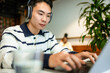 © DZ FILM/Stocksy - A man uses a laptop in a cafe