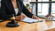 © Sabarudin - A woman in a suit signing documents with a model house