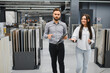 © Serhii - Seller assisting female buyer choosing tile in store