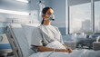 © NurAulia - A young woman wearing a respirator mask lies in a hospital bed in a modern medical facility.