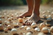 © Viktor - Bare feet walk on sand littered with broken eggshells. Precarious situation, fragile balance, risk and uncertainty. Careful stpic avoid damage. Sensitive journey, delicate path.