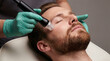 © Facundo - Handsome bearded man receiving professional facial treatment with microdermabrasion device in cosmetic clinic. Close up view of male skin care procedure by esthetician wearing green gloves.