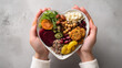 © Sabana - A person holding a heart shaped plate of various healthy foods and vegetables