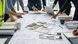 © Kurowo - Team collaborates on architectural plans examining blueprints and color swatches