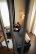 © Lomb - Woman relaxing at home reading a book and drinking a hot beverage on sofa during slow living moment