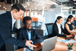 © Valerii Apetroaiei - Business Leader Guiding Employee in Modern Office