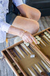 © Shava Cueva/Stocksy - Close-up of a hand playing backgammon on a table