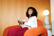 © Artem Podrez/Stocksy - Smiling businesswoman using smartphone in modern office with flash