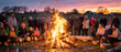 © Ahmed - Panoramic view of a large group of families and friends gathered around a glowing traditional Easter bonfire at sunset, with colorful eggs in baskets celebrating spring holiday traditions.