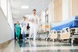 © Santi Nuñez/Stocksy - Medical team running in hospital corridor to emergency room