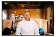 © Tlotliso Mapana/Stocksy - 60 year old man sitting on a sofa in his home