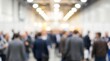 © CuteBee - An abstract, blurred photograph showcasing a large group of people walking through a brightly lit indoor hallway, creating a sense of movement.