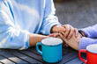 © Manu Padilla/Stocksy - Mother and daughter holding hands showing support and love at a table