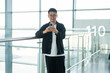 © Yic Ma/Stocksy - Asian Man Using Smartphone at Airport