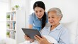 © Sarah - Caregiver assisting elderly woman with tablet