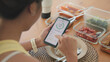 © ChayTee - Young adult black asia people active gen z using AI phone record data daily meal tracker clean food diet app control. Asian Smart living care happy life goal routine plan lunch time home dining table.