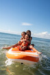 © Stephanie Tamir/Stocksy - Kids having fun on a paddle board