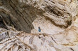 © JIE MA/Stocksy - A woman exploring natural wonders beneath sea-eroded cliffs.