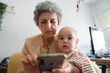 © Raul Navarro/Stocksy - Grandmother using smartphone