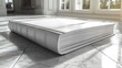 © zeni - Luxurious white leather-bound book on sun-dappled marble