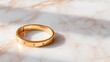 © Mr image - Golden Adornment on Marble: A single, radiant golden bracelet rests gracefully on a polished marble surface, showcasing its elegance and luxurious details in the soft interplay of light and shadow.