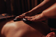 © fotokutkowska - Hot stone massage therapy in warm ambient light spa, relaxing body treatment with heated stones and massage oil on glowing skin, wellness ritual for stress relief and deep relaxation